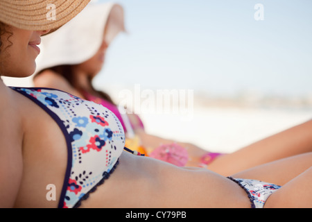 Attraktive junge Frau im Bikini am Strand liegen Stockfoto