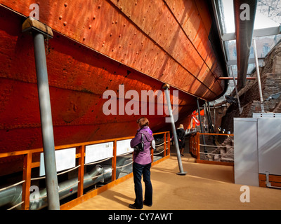 Besucher betrachten der eisernen Rumpf das Dampfschiff SS Great Britain von Brunel gebaut im Trockendock in Bristol Werften England UK Stockfoto