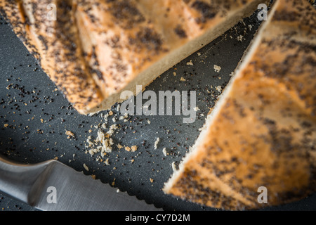 Geschnitten Sie Brot auf Schieferoberfläche Stockfoto