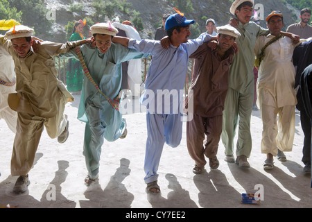 Kalash Männer tanzen in einer Linie mit der Kalash Joshi (Frühlingsfest), Grum Dorf Charso (Tanz Boden), Rumbur Tal, Chitral, Khyber-Pakhtunkhwa, Pakistan Stockfoto