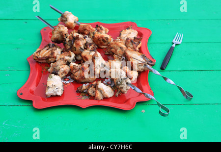 Schaschlik auf Tablett am grünen Tisch Stockfoto