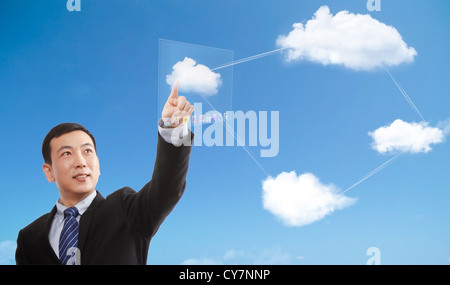 Ein Unternehmer mit einem Finger berühren eine Wolke Stockfoto