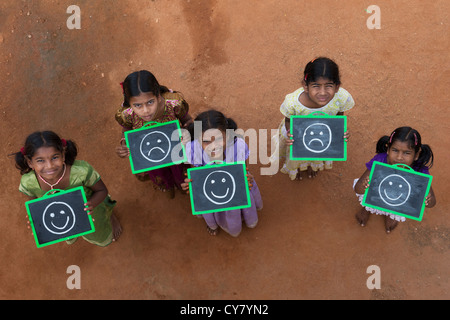 Fünf Mädchen, Indianerdorf mit HAPPY SAD steht und auf einer Tafel in einem indischen Dorf gezogen. Andhra Pradesh, Indien Stockfoto