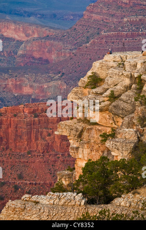 Person auf Felsen bei Sonnenuntergang in der Nähe von Yavapai Point, South Rim, Grand Canyon Nationalpark in Arizona Stockfoto