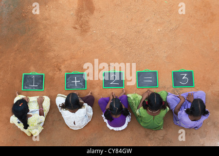 Fünf Mädchen, Indianerdorf mit 1 + 2 = 3 geschrieben auf einer Tafel in einem indischen Dorf. Andhra Pradesh, Indien. Kopieren Sie Raum. Stockfoto