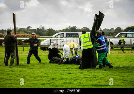 Gefallene Pferd wird tendenziell bei Wincanton Rennen verfolgen Somerset Stockfoto