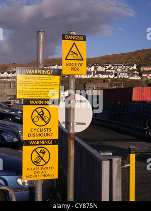 Leuchtend gelbe Warnzeichen auf dem Pier im Hafen von Mallaig in Nord-West-Schottland, UK Stockfoto