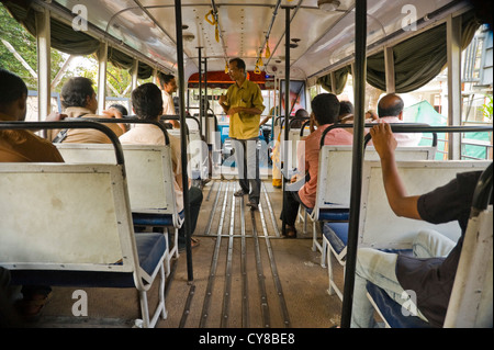 Horizontale Innenansicht eines öffentlichen Busses in Kerala mit Dirigent Tarife zu sammeln. Stockfoto