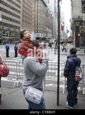 Kleiner Junge schaut zum Himmel auf Papas Schultern durch die Wolkenkratzer in Midtown Manhattan Stockfoto