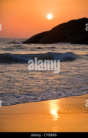 Vertikale Blick auf den Sonnenuntergang über den tosenden Wellen in Kerala, Indien. Stockfoto