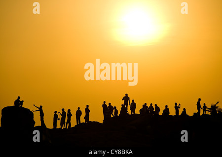 Horizontale Ansicht derjenigen, die gegen der untergehende Sonne in Kovalam, Kerala. Stockfoto