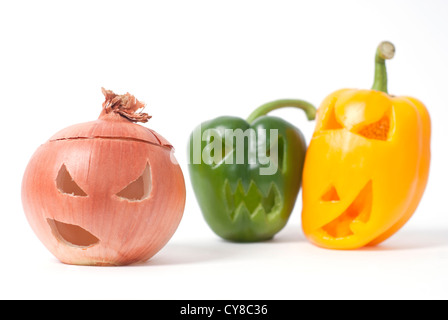 Halloween Gesichter geschnitzt in Zwiebeln und gelbe und grüne Paprika Gemüse statt Kürbis bilden spezielle Jack-o-Laternen. Stockfoto