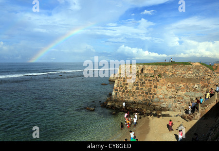 Regenbogen über das Meer und die Menschen am Strand an den Außenwänden der Galle Fort. Stockfoto