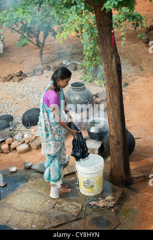 Junge indische Frau Wäsche vor ihrem Haus in einem indischen Dorf. Andhra Pradesh, Indien Stockfoto