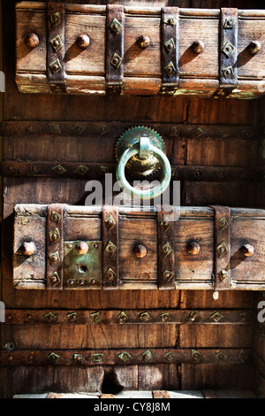 Balinesischen Stil großen geschnitzten Holztüren in Bali Indonesien mit Metall Türklopfer und Nieten. Stockfoto