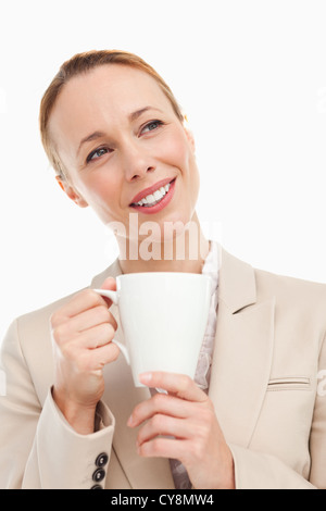 Rothaarige Frau in einem Anzug hält einen Becher Stockfoto