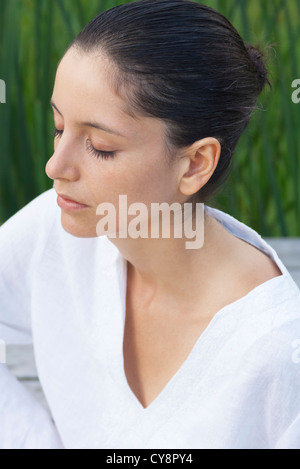 Junge Frau mit geschlossenen Augen meditiert, portrait Stockfoto