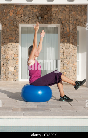 Junge Frau, die Übung auf Fitness-ball Stockfoto