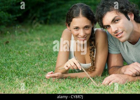 Junges Paar liegen zusammen auf dem Rasen, Porträt Stockfoto