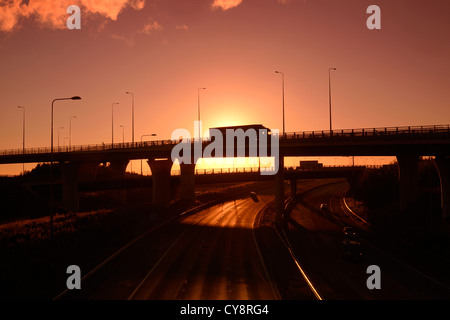 LKW unterwegs Holmfield Junction verbindet die Autobahnen A1 M1 und M62 bei Sonnenuntergang Leeds Yorkshire UK Stockfoto