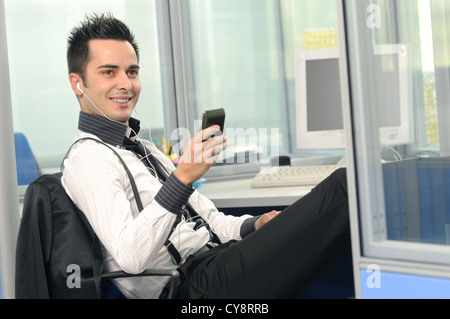 Junger Geschäftsmann Musik hören Stockfoto