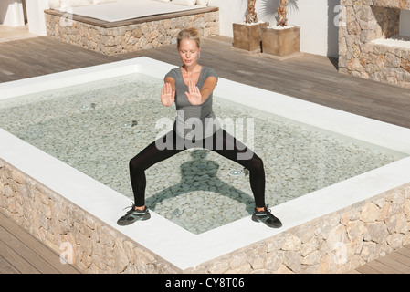 Junge Frau praktizieren Tai Chi Chuan im Patio mit Augen geschlossen Stockfoto