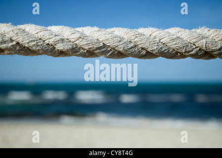 Nahaufnahme von verwitterten Seil mit Strand im Hintergrund Stockfoto