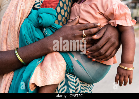 Armen niedrigere Kaste Indianerin Baby im Tragetuch tragen. Andhra Pradesh, Indien Stockfoto