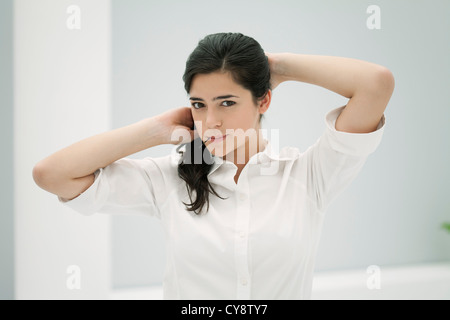 Junge Frau Befestigung Haar, hielt Haarnadel in Mund Stockfoto