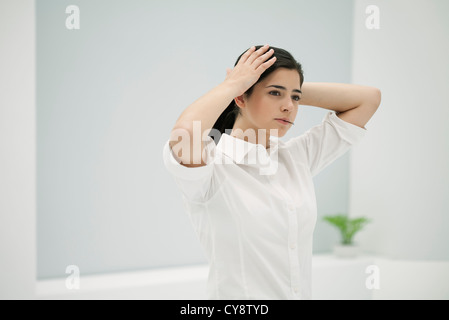 Junge Frau Befestigung Haar, hielt Haarnadel in Mund Stockfoto