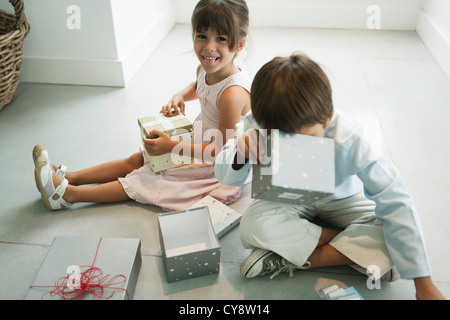 Kinder sitzen auf Bodenöffnung Geschenke Stockfoto
