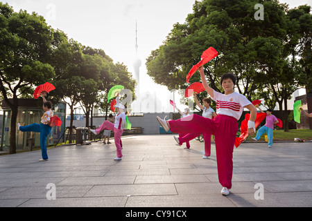 Chinesische Frauen führen Sie am frühen Morgen fan-Übung auf den Bund Shanghai, China Stockfoto