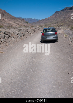 Aride Landschaft mit Vw Polo Auto unterwegs auf Veneguera Gran Canaria Kanaren Spanien Stockfoto