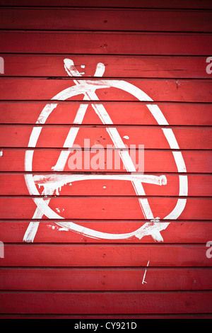 Anarchie-Zeichen auf rote Wand in weißer Farbe bemalt. Stockfoto
