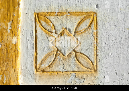 Traditionelles geometrisches Motiv gemalt gelb geschnitzt auf einer weißen Wand, Alentejo, Portugal Stockfoto
