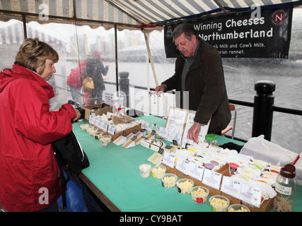 Mann, Verkauf von Northumbrian Käse in einem Stall auf Newcastle Quayside Markt Nord Ost England UK Stockfoto