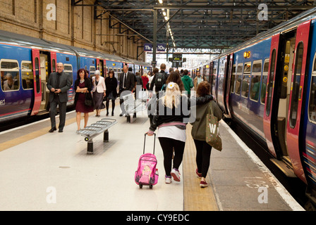 Fahrgäste im Eisenbahnverkehr fangen einen Zug, der Plattform, Kings Cross Bahnhof, London UK Stockfoto