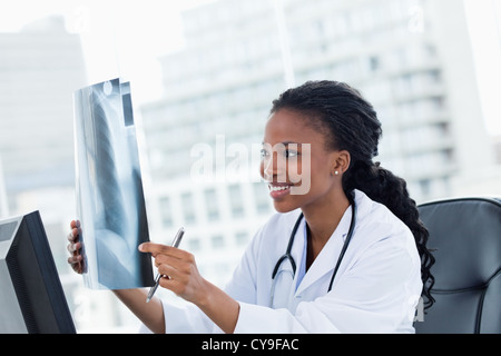 Zufrieden Ärztin Blick auf eine Reihe von Röntgenstrahlen Stockfoto