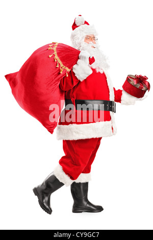 In voller Länge Portrait von Weihnachtsmann zu Fuß mit Tasche und Geschenk in seinen Händen isoliert auf weißem Hintergrund Stockfoto