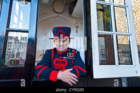 Jovial Yeoman Warder (Beefeater) im Dienst in seiner traditionellen Sicherheit Prüfpunkt Stand auf der Tower of London Stadt von London UK Stockfoto