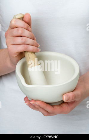 Frau mit Stößel und Mörser Stockfoto