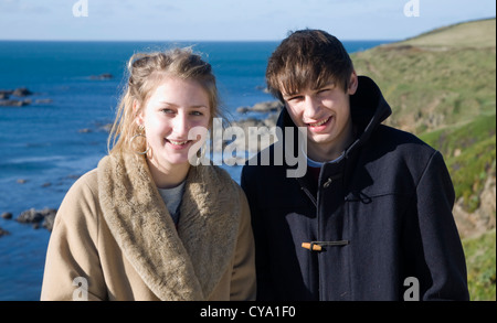 Neunzehn Jahre alte junge Mädchen Zwillinge Porträt im Freien direkt am Meer im Wintermäntel Stockfoto