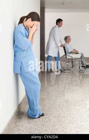 Betonte Krankenschwester Wand gelehnt Stockfoto