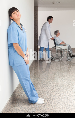 Müde Krankenschwester Wand gelehnt Stockfoto