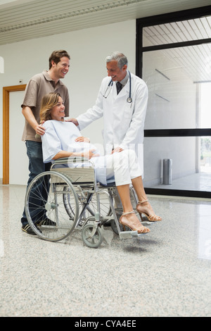 Arzt spricht mit einer schwangeren Patienten im Rollstuhl Stockfoto