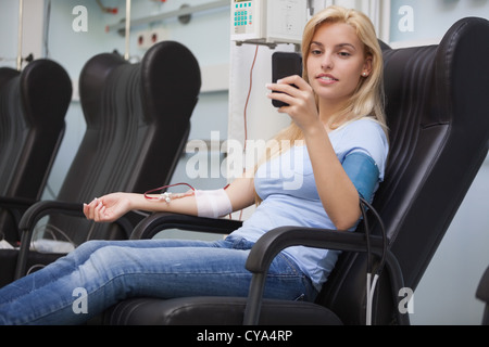 Blonde Frau in einem Stuhl während Dialyse immer entspannend Stockfoto