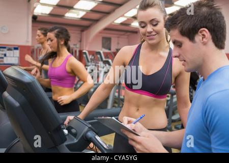 Trainer helfen eine Frau in einem Fitnessstudio Stockfoto