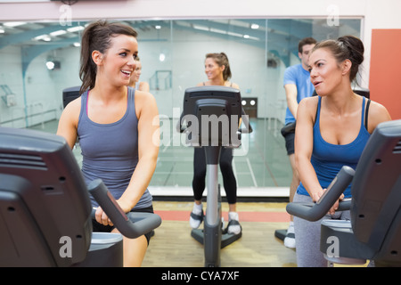 Zwei Frauen reden während des Trainings in einem Spinning Kurs Stockfoto