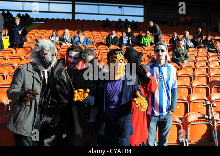 Fußballfans von Brighton und Hove Albion tragen Halloween-Outfits für das Spiel mit den britischen Halloween-Kostümen von Blackpool Town Stockfoto