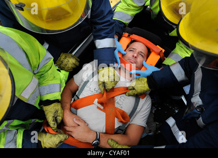 Feuerwehrmann der weißen Uhr in Pontypridd Feuerwache in S Wales - eine Trainingseinheit zu üben, die das Opfer von einer Straße Traf entfernen Stockfoto
